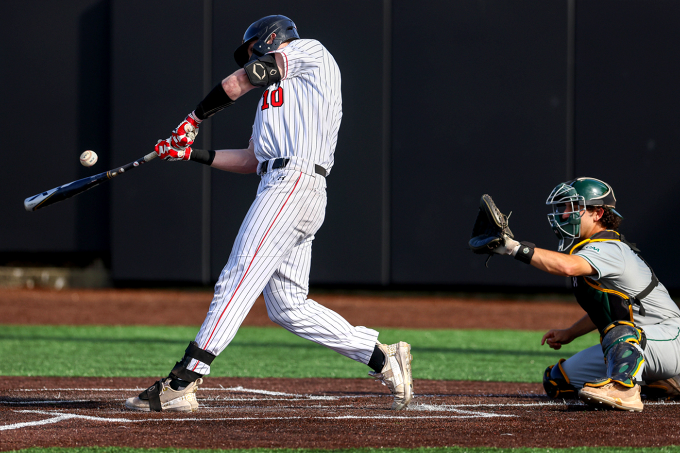 Huskies baseball player hitting the ball with the bat