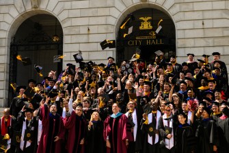 graduates throwing their caps and gowns in the air