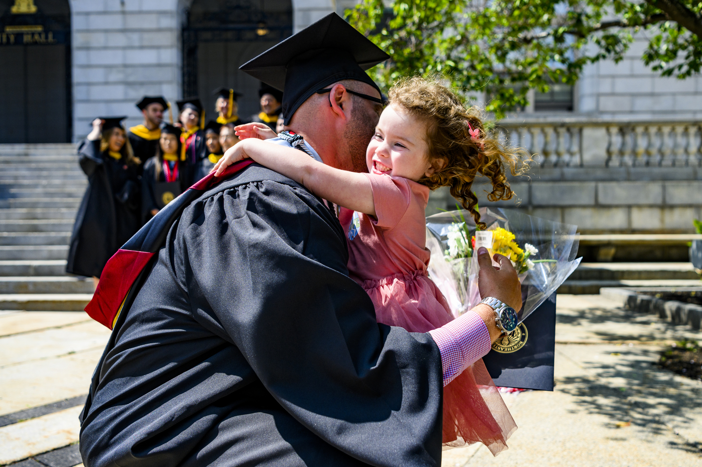 graduate hugging a child