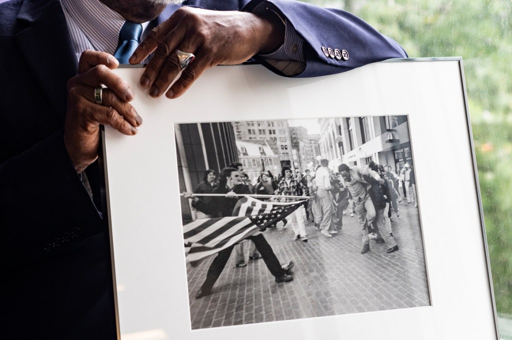 Ted Landsmark holding photograph The Soiling of Old Glory