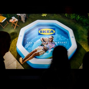 A person lounging in an inflatable pool on the screen