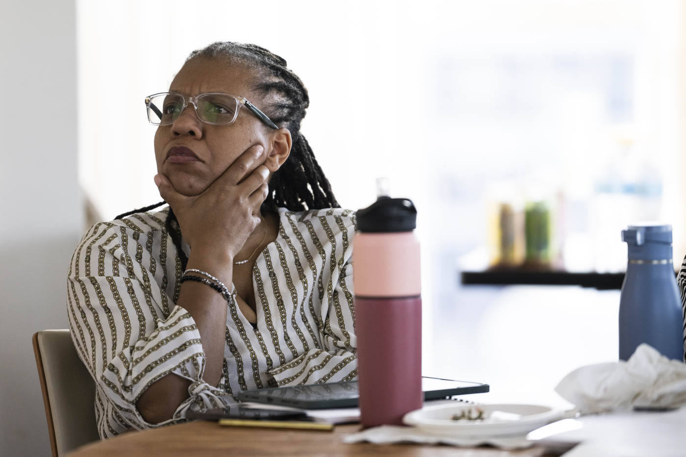 A person listens to a speaker while sitting at a table.