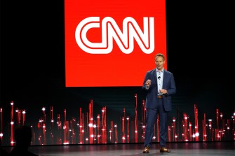 Chris Licht standing in front of CNN logo