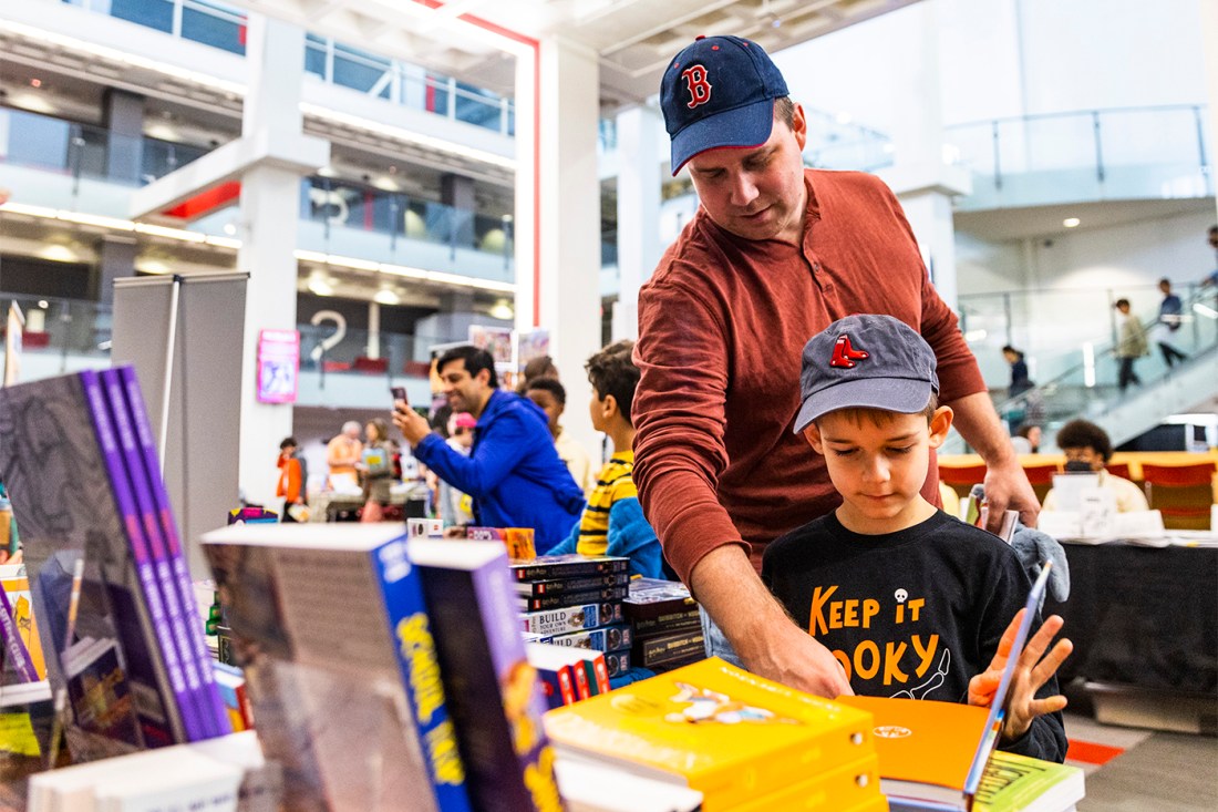 A father and son look at a graphic novel