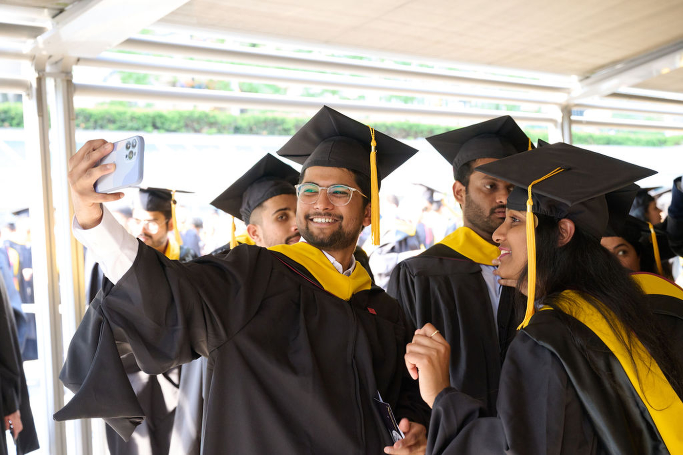 Graduates taking pictures at Northeastern's Toronto convocation.