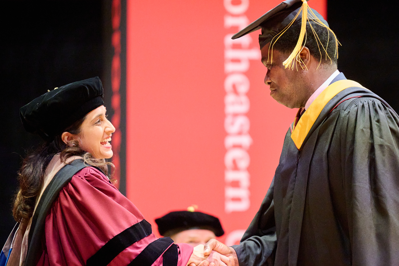 Emmanuel Nasamu shaking hands with Aliza Lakhani