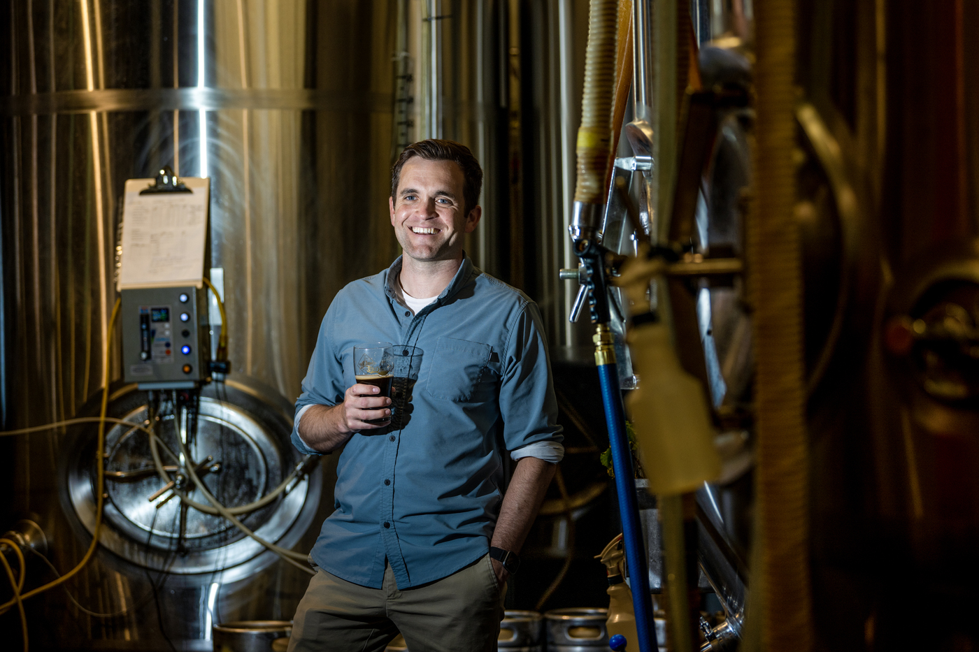 Sean Sullivan at the brewery, holding a glass of beer.