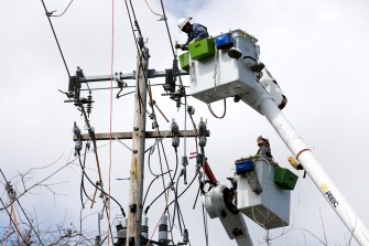 workers standing on crane lifts working on power lifts