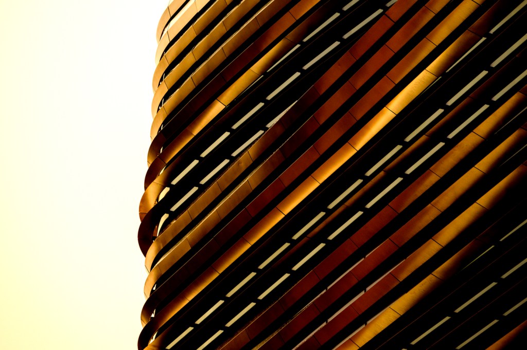 The exterior of Northeastern's EXP building glimmers and takes on a golden color in the sunlight.