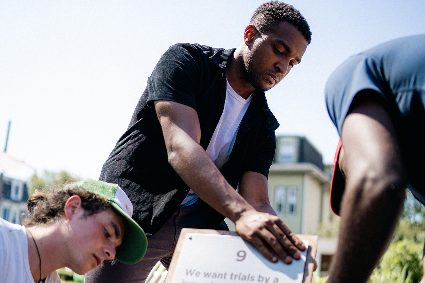 three people work together to install art in Winthrop Community Garden