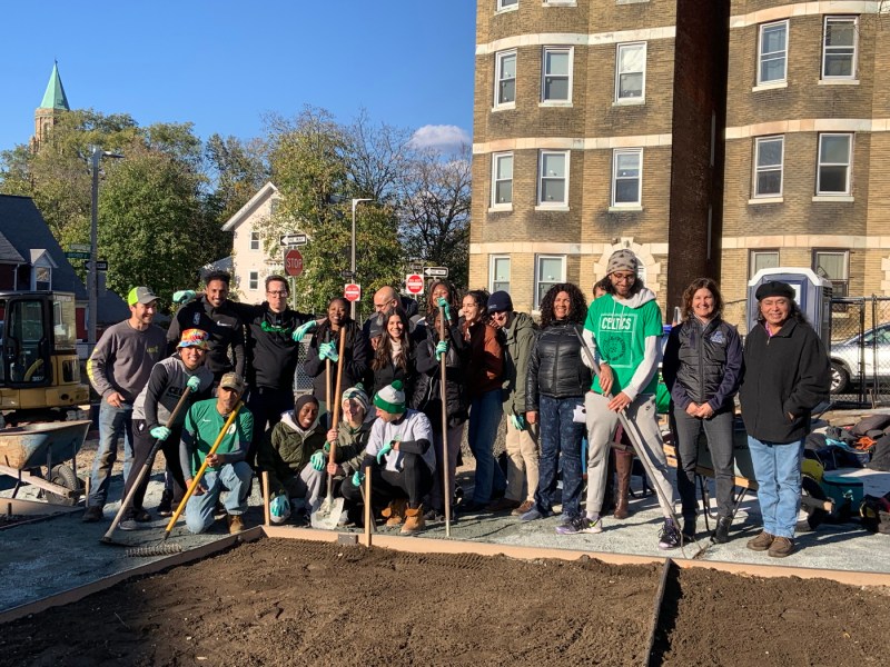 group photo of people posing in front of a garden bed