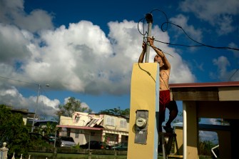 A resident of Puerto Rico tries to connect electrical lines.