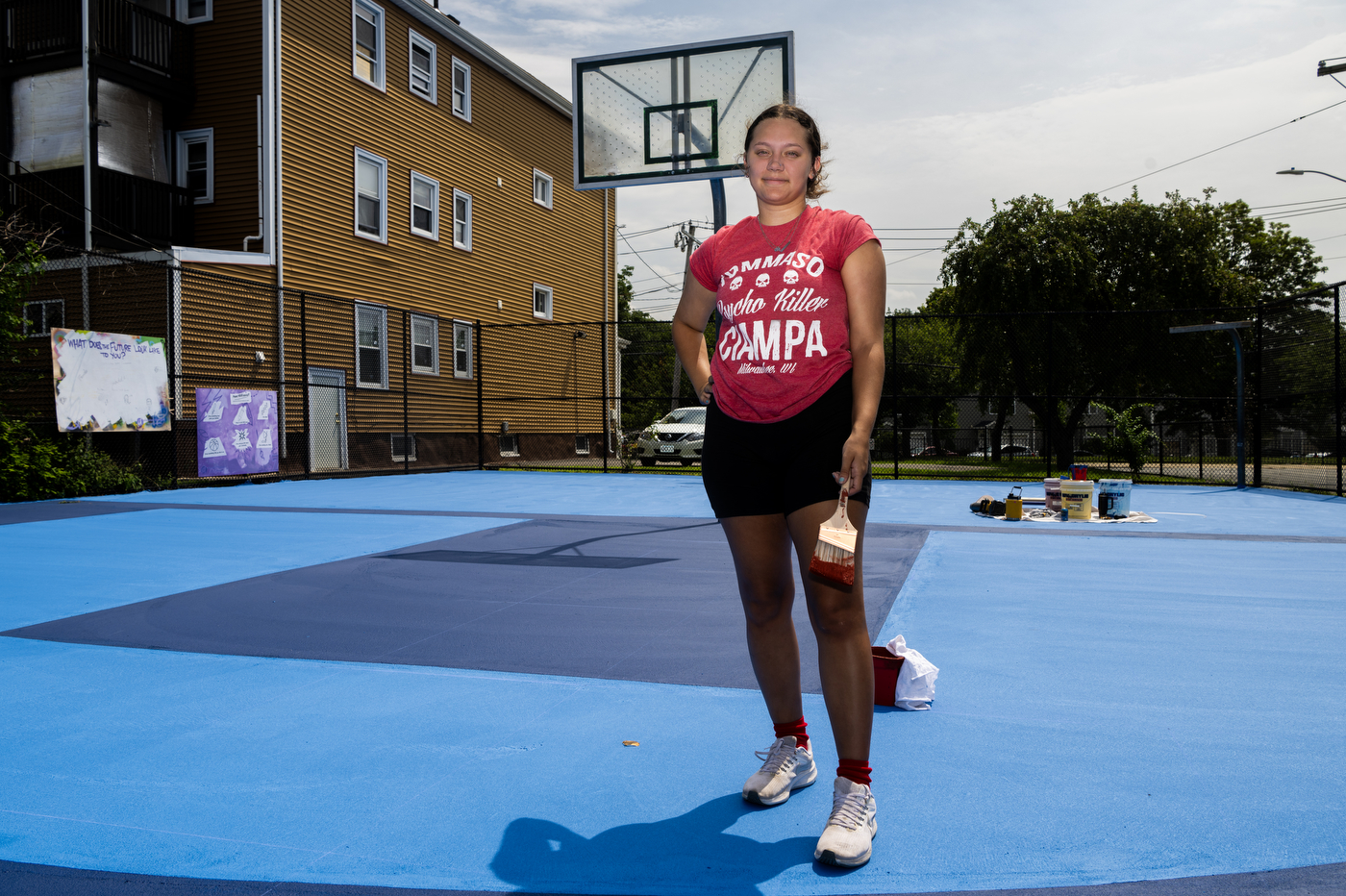 Kaiya Santos painting a basketball court