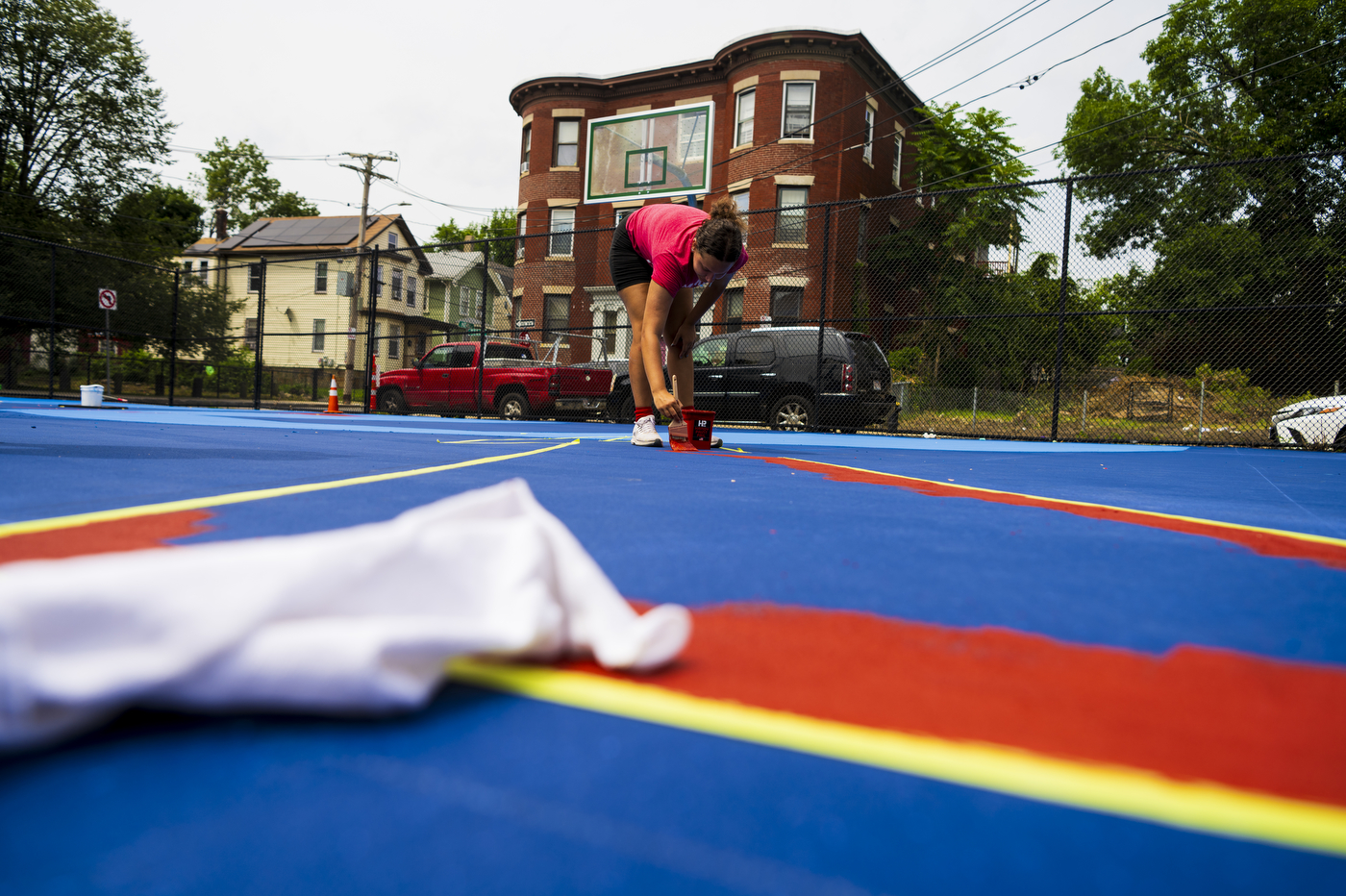 Kaiya Santos working on basketball court painting