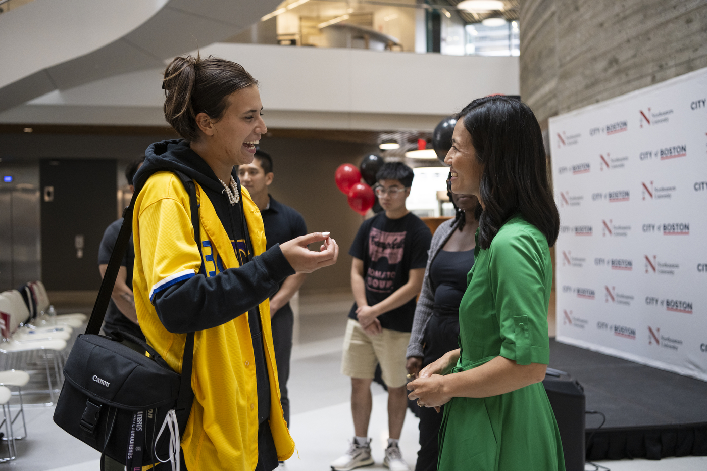 Mayor Michelle Wu meeting with someone holding a camera bag