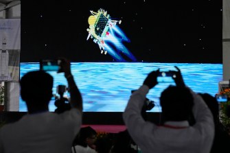 Journalists filming the telecast of India's spacecraft landing with their phones