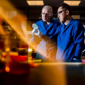 Kim Lewis and Yu Imai in a lab