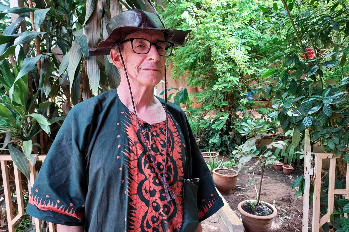 Headshot of William Miles outdoors in a garden.