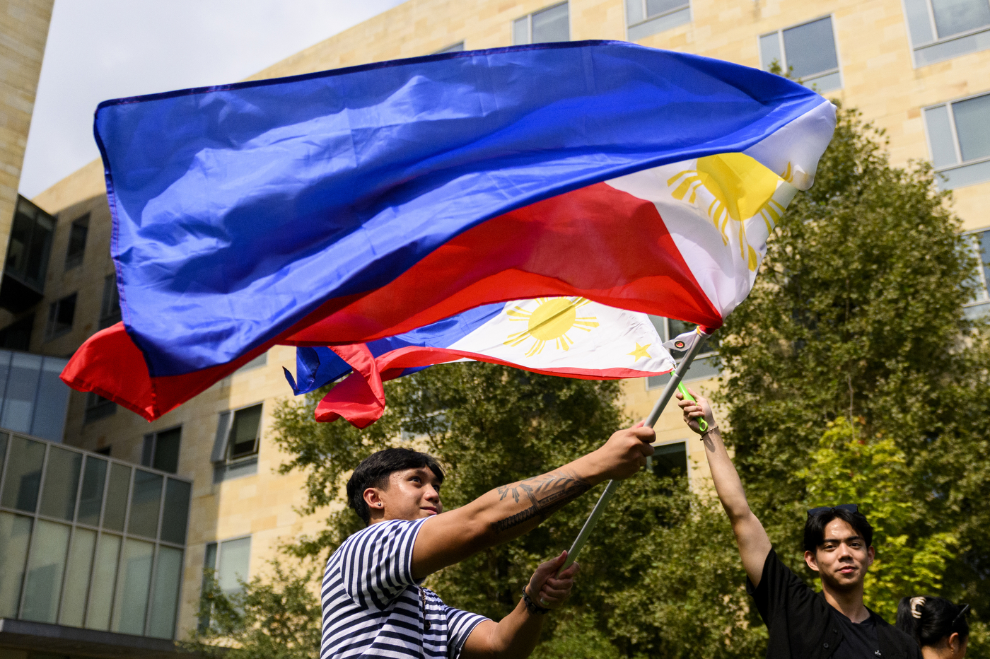 Two people swing around multi-colored flags at Fall Fest.