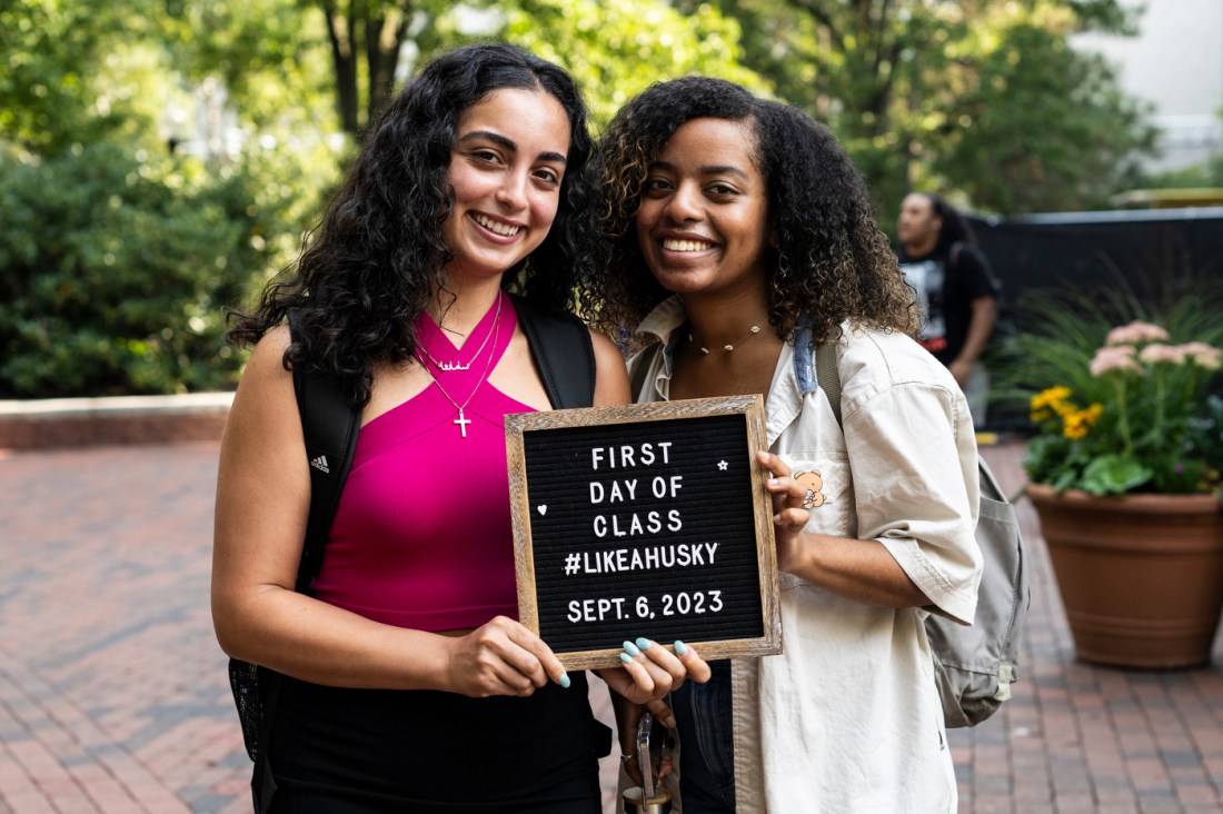 two students posing with a first day of class letterboard