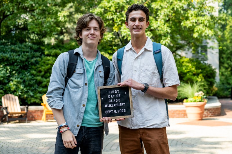 two students posing with a first day of class letterboard