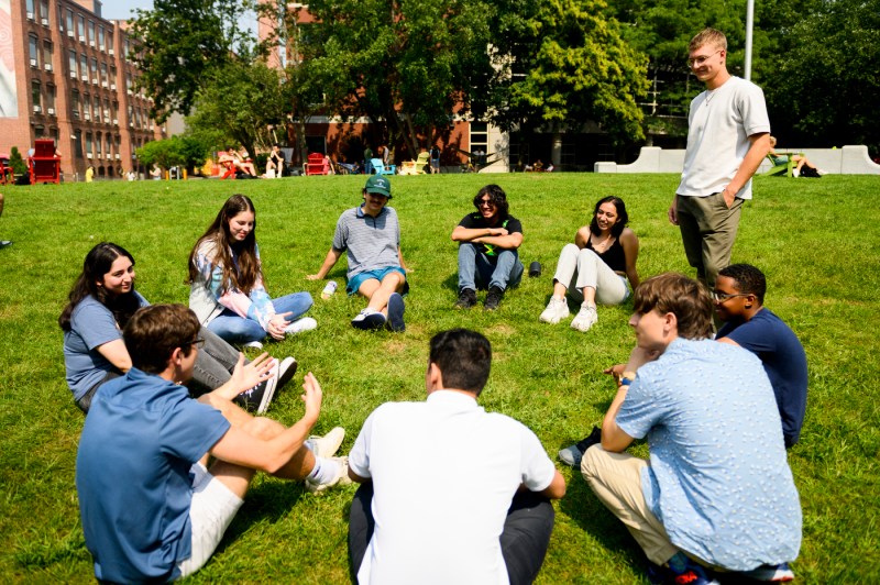 students sitting in a circle on the grass