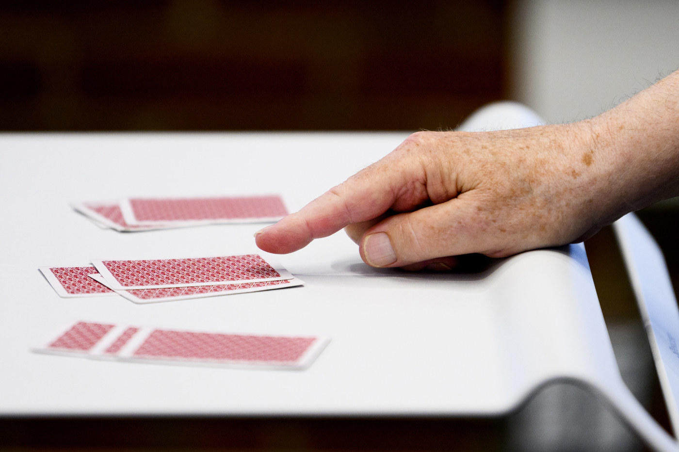 Stanley Eigen pointing to a stack of cards on a table. 