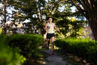 Laura Green, an influencer comedian, runs through a park on a sunny day.