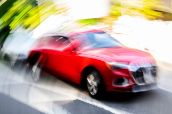 Slow shutter photo of a Red Audi SUV.