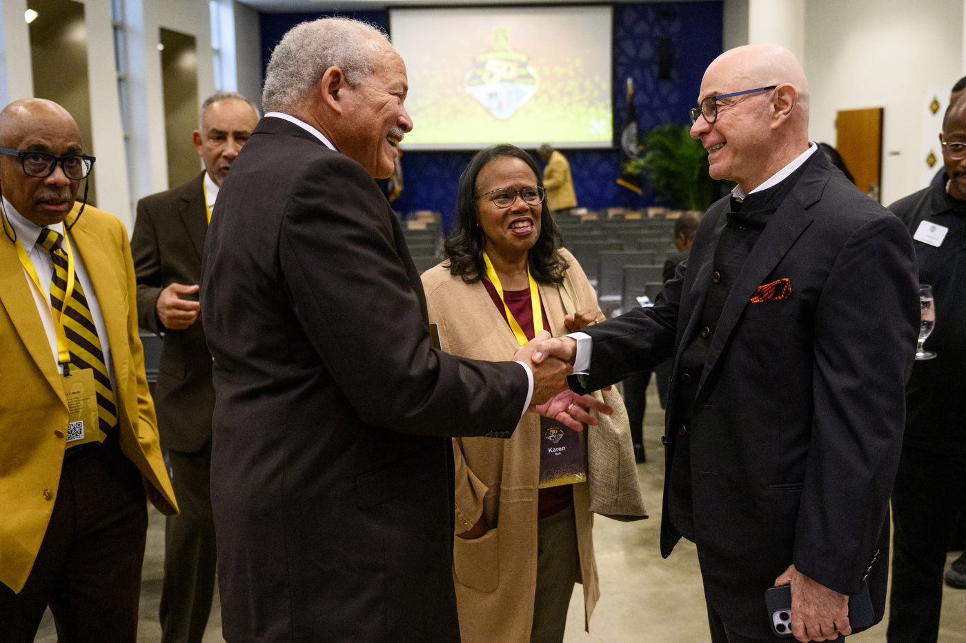 President Aoun shaking hands with a member of Iota Phi Theta.