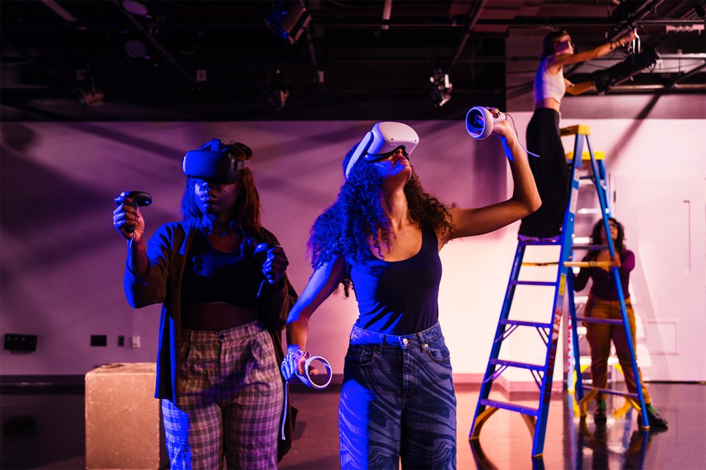 Two students wearing virtual reality headsets on set in Ryder Theater Lab.