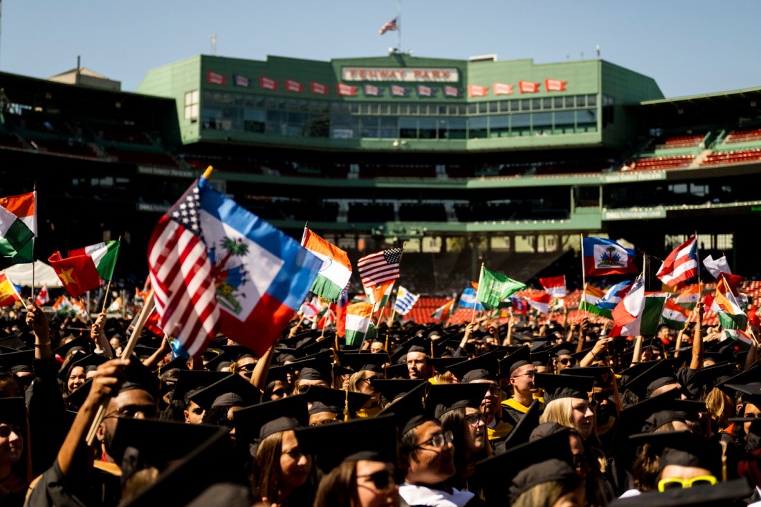 Graduates gathered in Fenway Park for the graduation ceremony; raising flags from their many home countries.