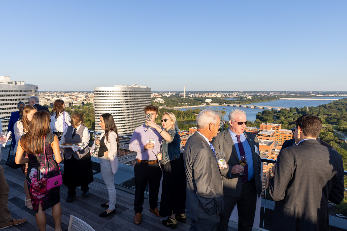 People on a rooftop posing for selfies at the Experience Powered by Northeastern campaign stop in Arlington.