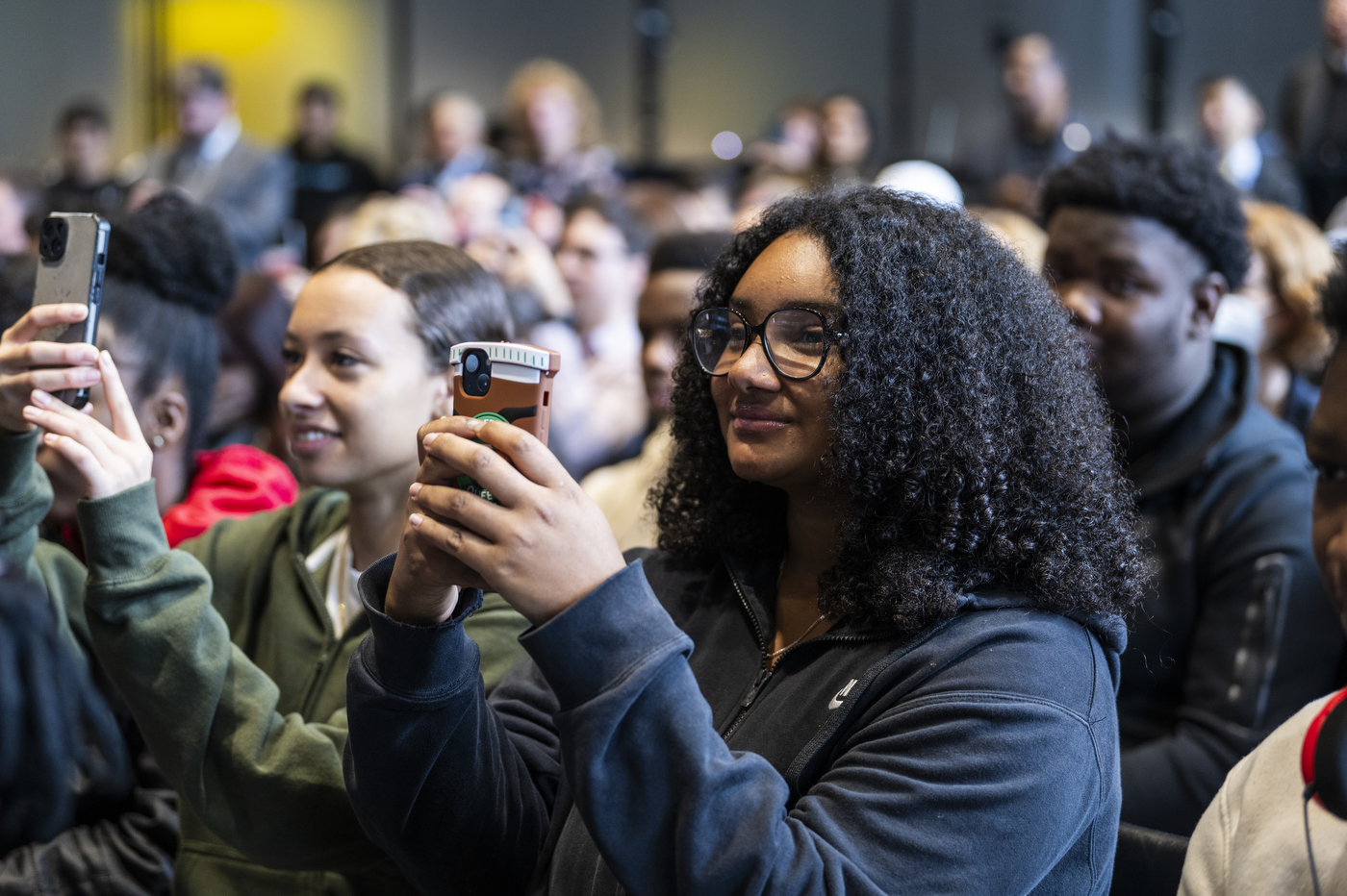 Audience members recording during the EXP grand opening. 