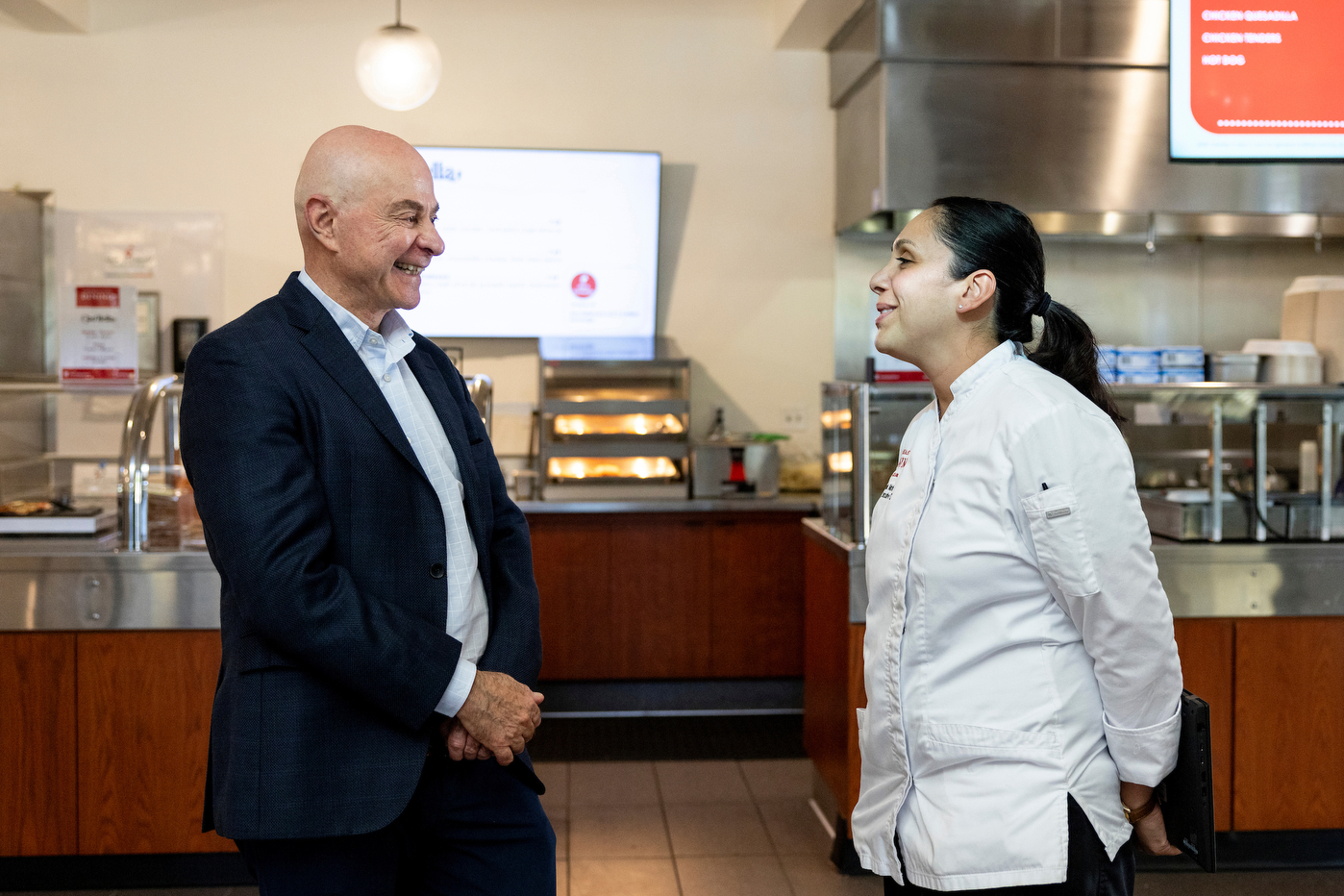 President Aoun speaking with a dining hall staff member.