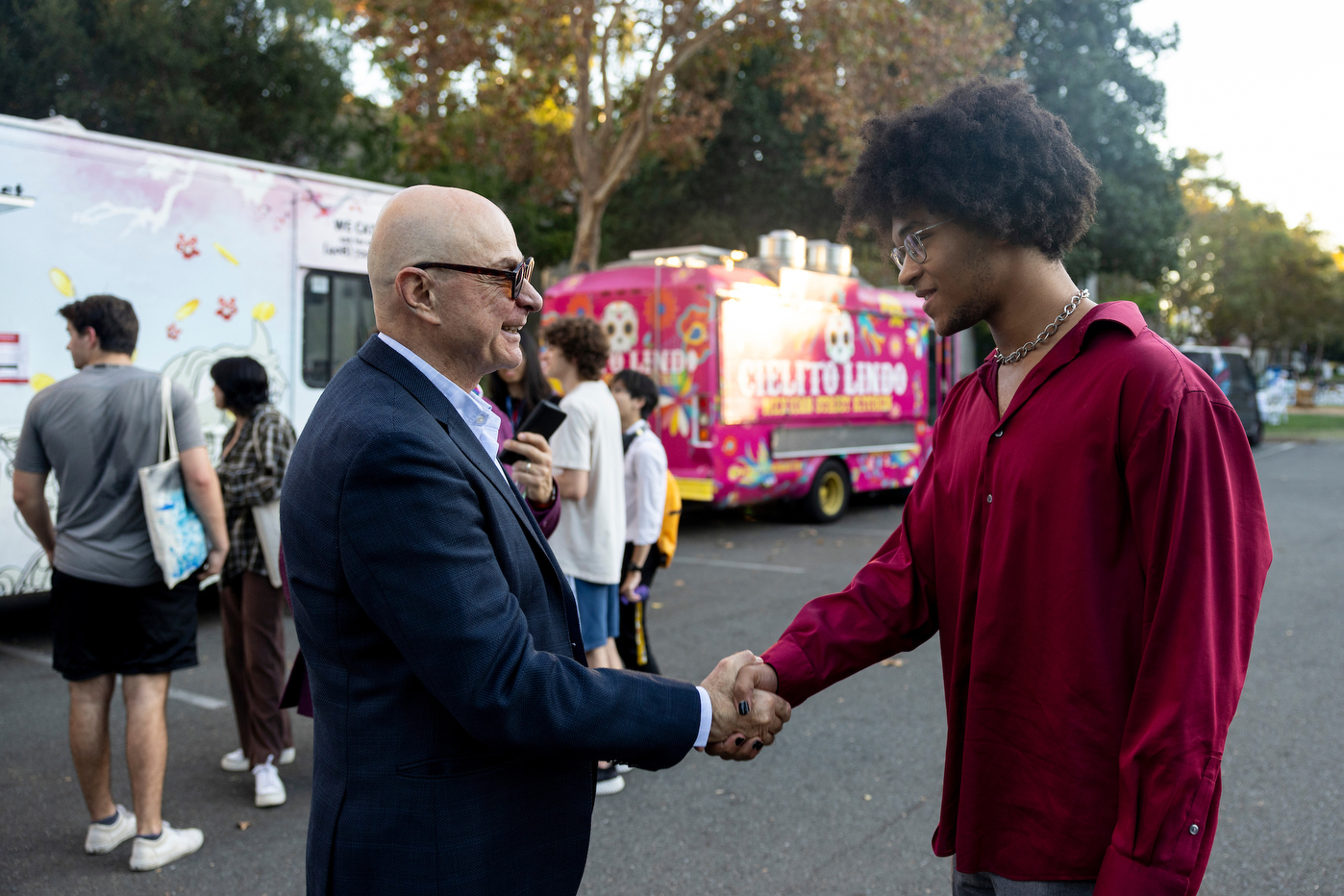 President Aoun shaking a student's hand on campus. 