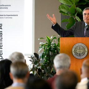 Speaker gesturing at the AI Business Leaders Conference.