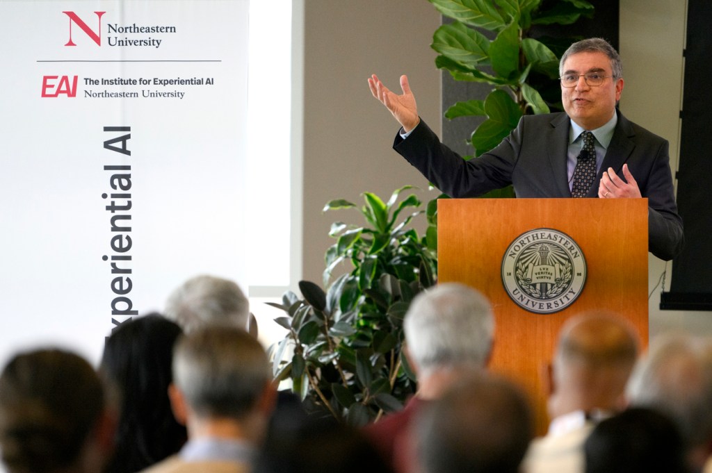 Speaker gesturing at the AI Business Leaders Conference.