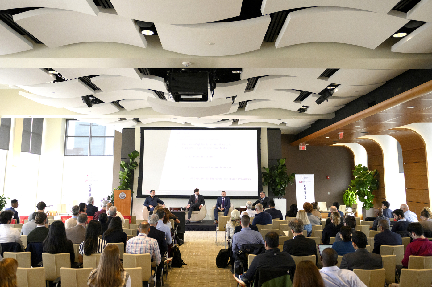 Room full of panelists and audience members at the AI Business Conference.