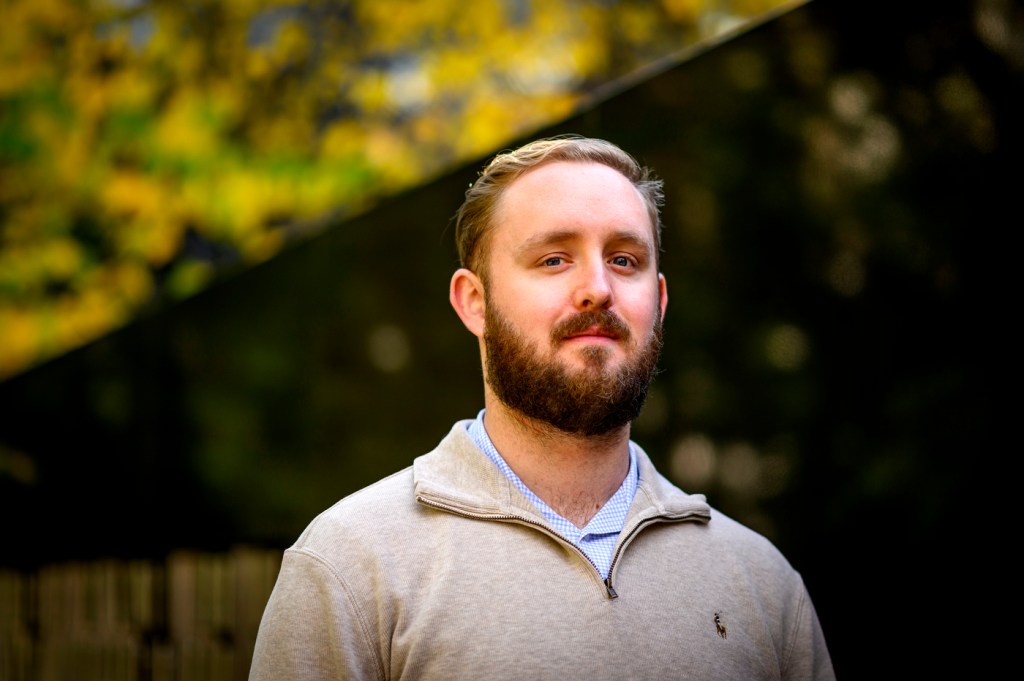 Michael Lennon posing for a headshot outside.