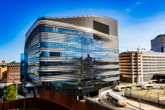 The exterior of Northeastern's EXP building glimmers in the sunlight.