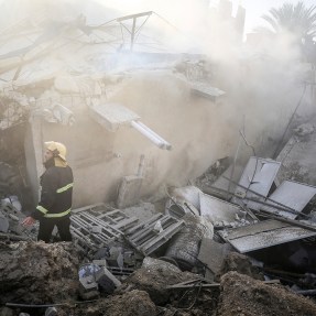 Men walking through rubble in Gaza.