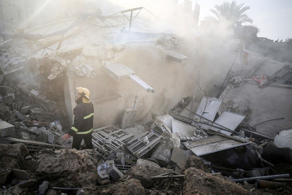 Men walking through rubble in Gaza.