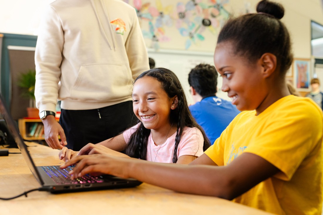 Two students working on a laptop together.