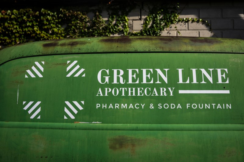 Green sign that says 'Green Line Apothecary Pharmacy & Soda Fountain' on it