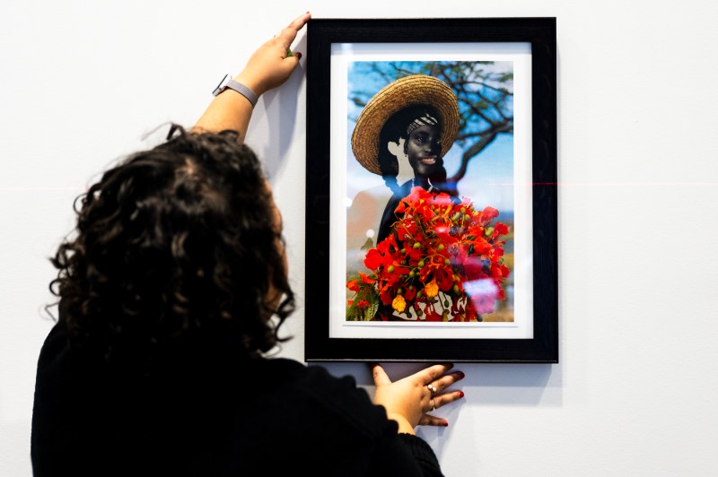 Person installing a piece of art on the wall.