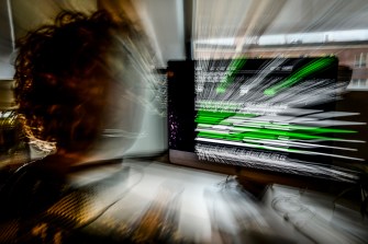 Long exposure photo of a person looking at an AI chatbot on their screen.