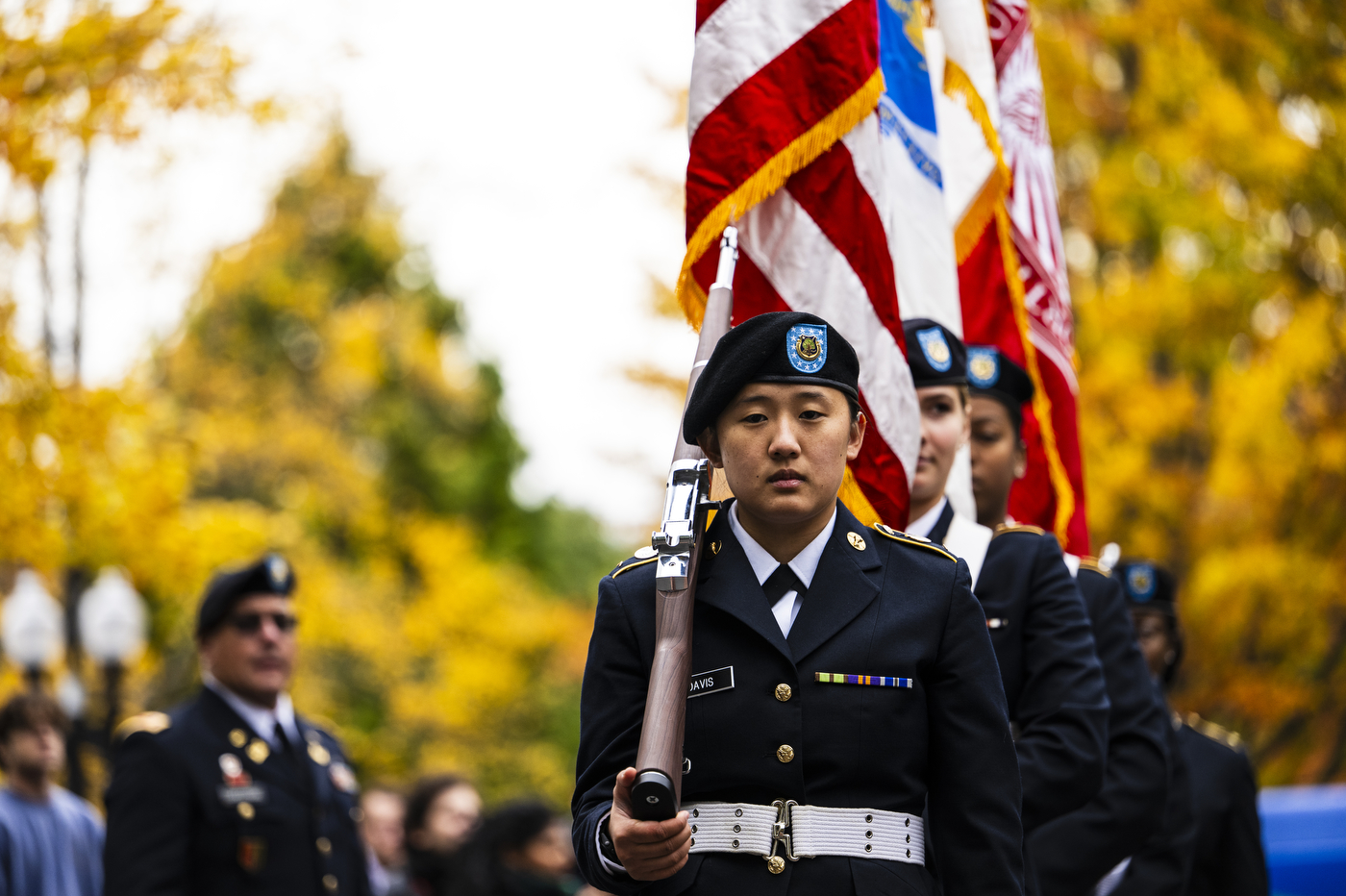 Military members standing in salute at the Northeastern Veterans Day Ceremony