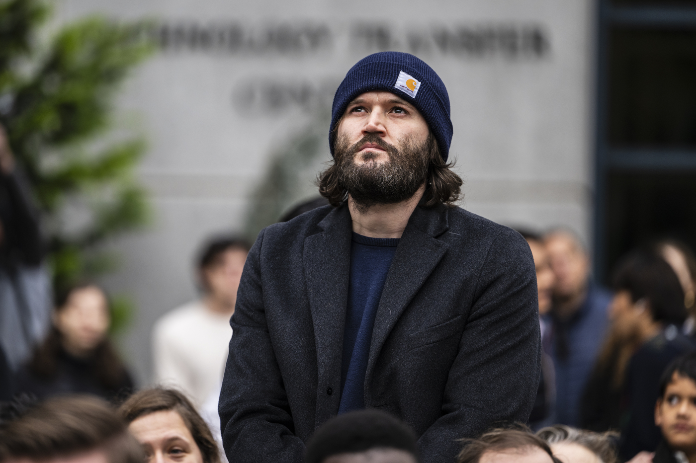 Person in a winter hat and coat at the Veterans Day ceremony.