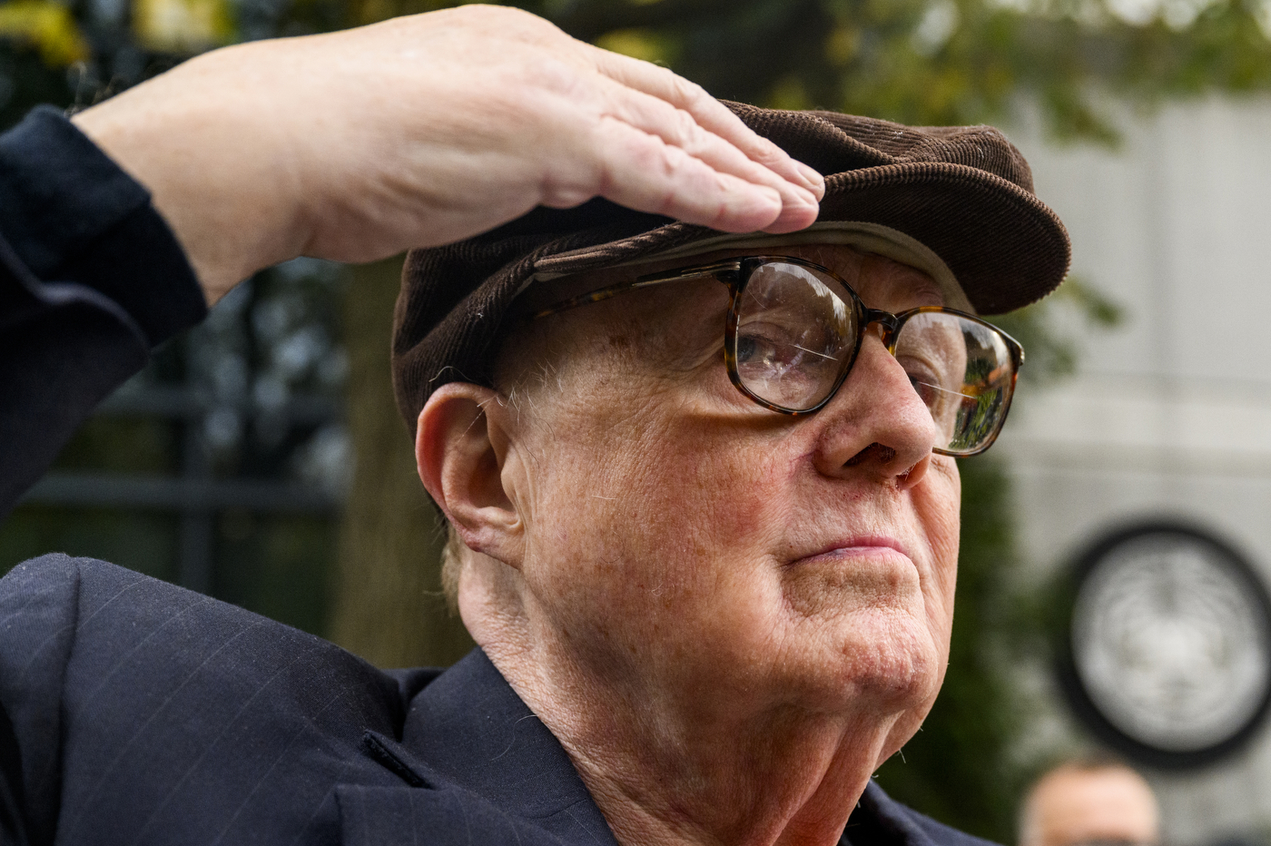 Person standing in salute at the Veterans Day ceremony.